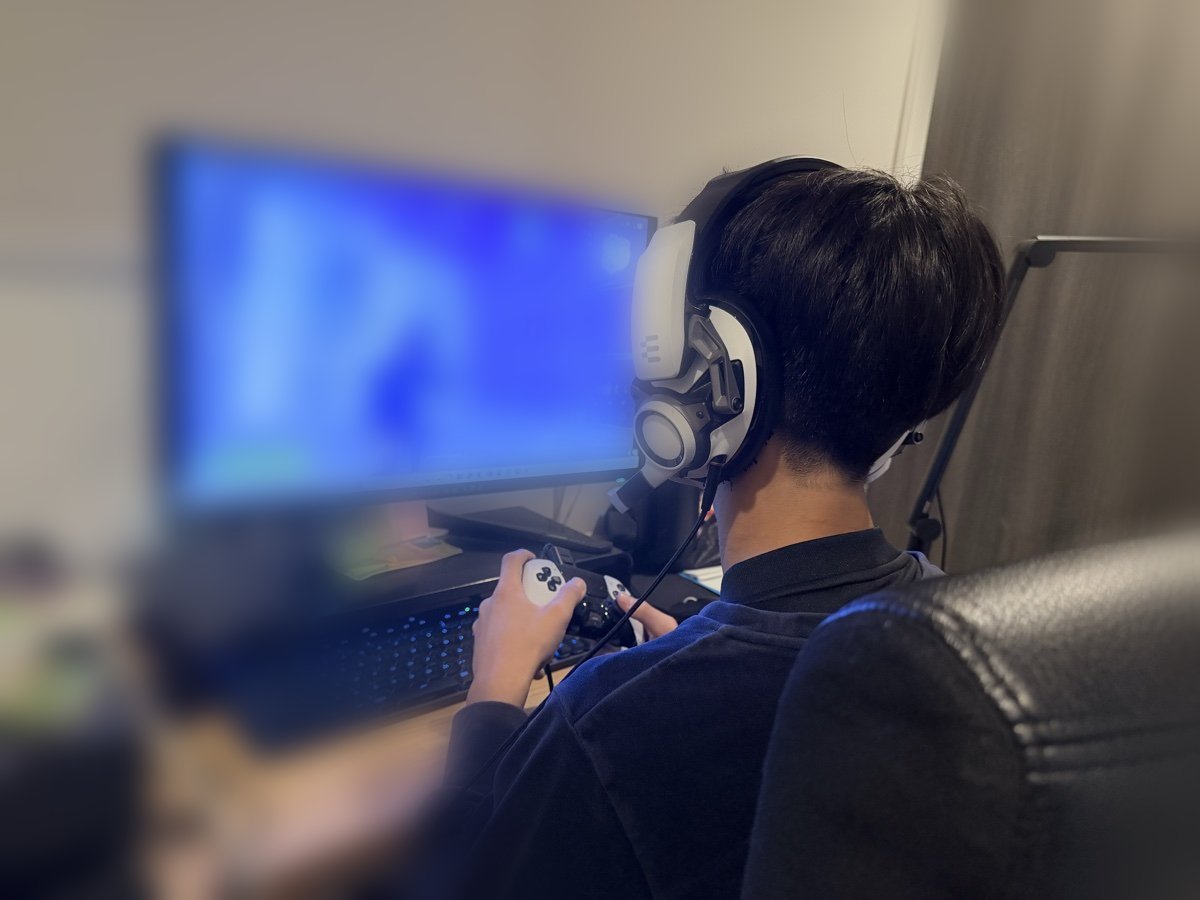 eスポーツ英会話のレッスン環境:ヘッドセットを着けてPCでフォートナイトをプレイする中学生の息子