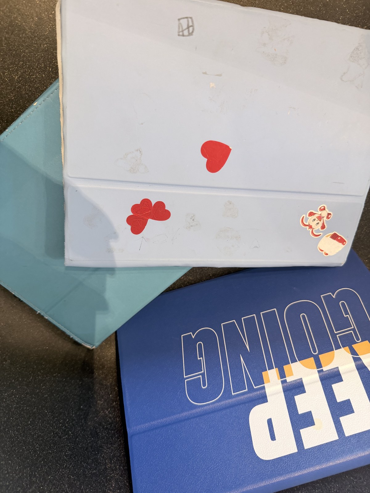 進研ゼミのチャレンジタッチ3台分のカバー。シールや落書きの跡が10年の歴史