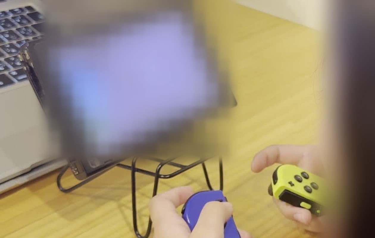 Switchでコーチの世界に入り、Joy-Conを持つ小2の娘の手元(ゲーム画面はぼかしています)